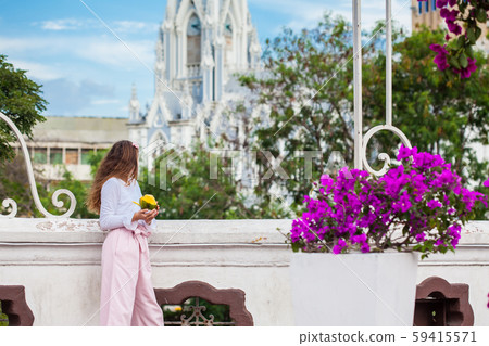 Beautiful young girl on the Ortiz Bridge eating a mango in front of the gothic church of La Ermita Beautiful young girl on the Ortiz Bridge eating a mango in front of the gothic church of La Ermita 59415571