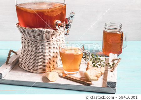Fresh homemade kombucha fermented tea drink in a jar with faucet and in a cup and in mug on a white 59416001