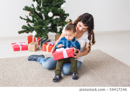 Christmas, single parent and holidays concept - Cute little boy holding christmas present for his Christmas, single parent and holidays concept - Cute little boy holding christmas present for his 59417246