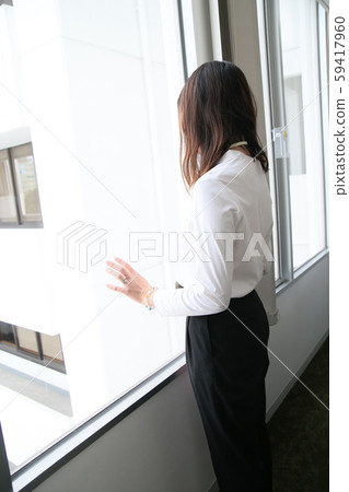 一位女僱員,看著窗外,就好像在回家一樣(垂直) 一位女僱員,看著窗外,就好像在回家一樣(垂直) 59417960