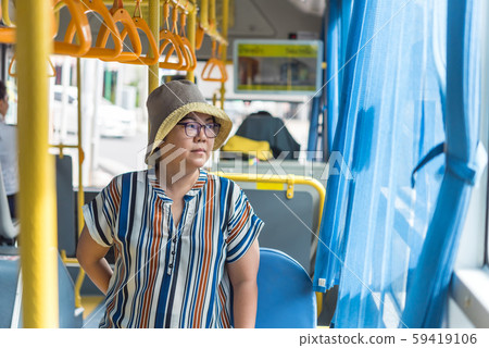 Asian woman travel by passenger bus in city 59419106