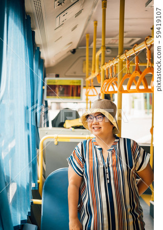 Asian woman travel by passenger bus in city 59419107