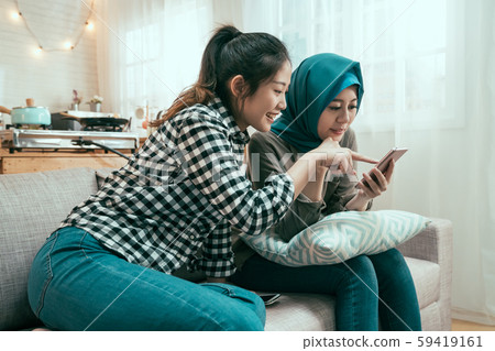 Euphoric friends watching video on smartphone 59419161