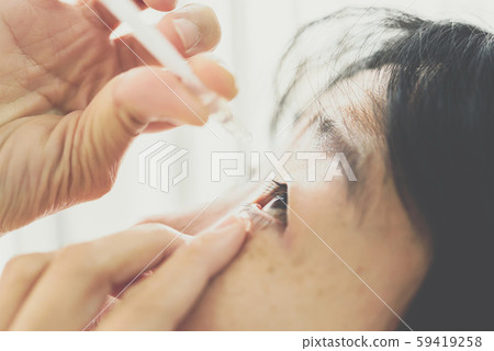 Woman use eye drop, artificial tears to the eye Woman use eye drop, artificial tears to the eye 59419258