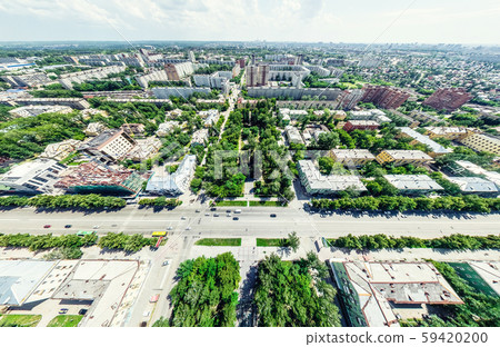 Aerial city view with crossroads and roads, houses, buildings, parks and parking lots. Sunny summer Aerial city view with crossroads and roads, houses, buildings, parks and parking lots. Sunny summer 59420200