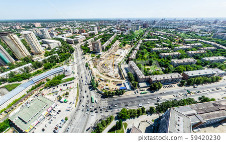 Aerial city view with crossroads and roads, houses, buildings, parks and parking lots. Sunny summer 59420230
