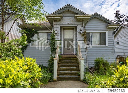 Neglected shabby residential house on blue sky background. 59420683