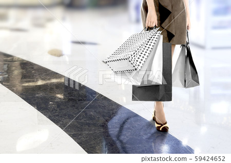 A woman carrying a shopping bag in the mall A woman carrying a shopping bag in the mall 59424652