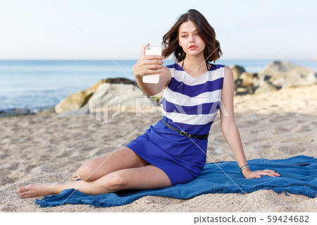 Young girl resting and taking selfie 59424682