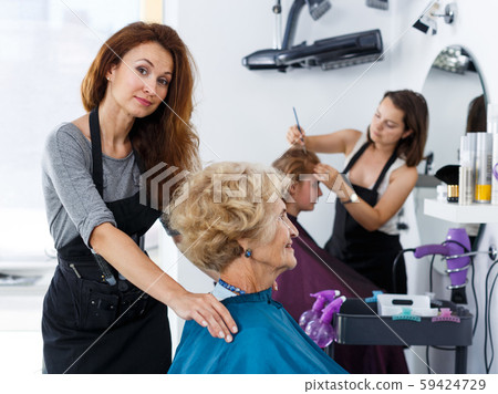 Stylist preparing customer for hair styling 59424729