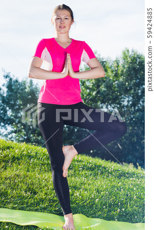 Female 20-30 years old is staying and practicing meditation in pink T-shirt Female 20-30 years old is staying and practicing meditation in pink T-shirt 59424885