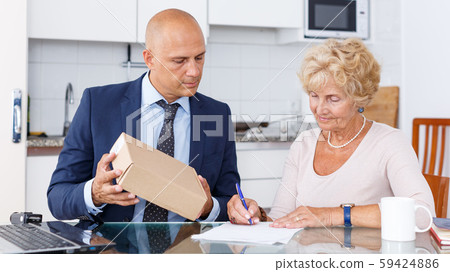 Agent helping to elderly woman Agent helping to elderly woman 59424886