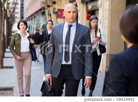 Business man walking on city street 59424982