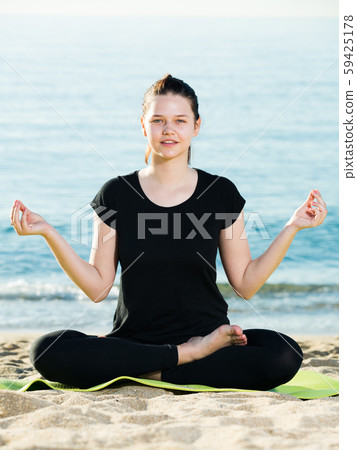 Adult woman in black T-shirt is sitting and practicing asana Adult woman in black T-shirt is sitting and practicing asana 59425178
