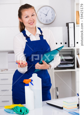 Cheerful female cleaner is signing documents while cleaning Cheerful female cleaner is signing documents while cleaning 59425179