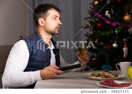 Man having christmas dinner and watching tv at home Man having christmas dinner and watching tv at home 59425315