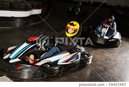 Female driving go-kart car indoor 59425497