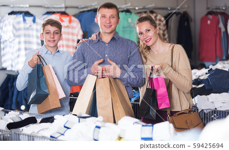 Smiling couple and teenager with shopping bags Smiling couple and teenager with shopping bags 59425694