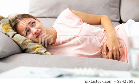 Woman suffering from abdominal pain 59425695