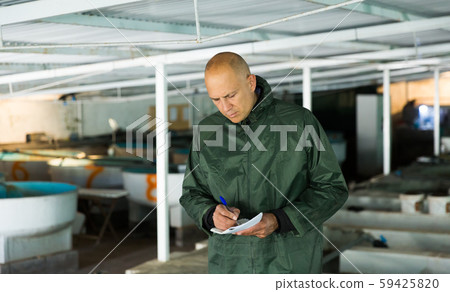 Owner of trout farm checking reservoirs with fry Owner of trout farm checking reservoirs with fry 59425820