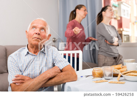 Family quarrel between the sisters. Elderly father sitting at the dinner table Family quarrel between the sisters. Elderly father sitting at the dinner table 59426258