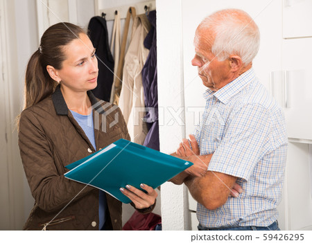 Businesswoman trying to collect arrearages from erderly man at home door 59426295