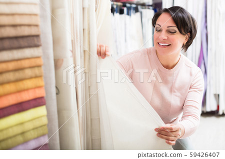 Customer posing near cloth rolls 59426407