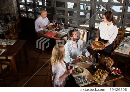Waitress bringing dishes to guests 59426808