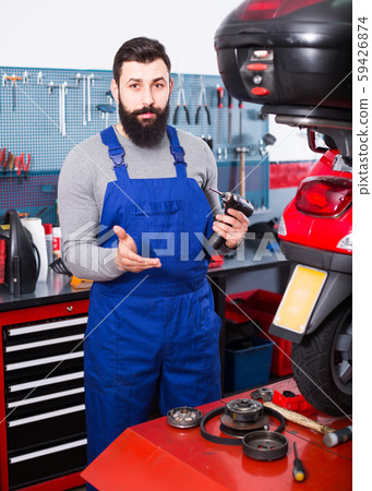friendly man worker ready to repair motorcycle in workshop friendly man worker ready to repair motorcycle in workshop 59426874