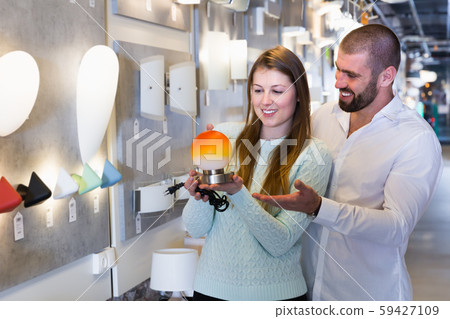 Portrait of family couple choosing nightlight in shop 59427109