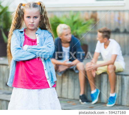 Upset girl after quarrel with playmates 59427160