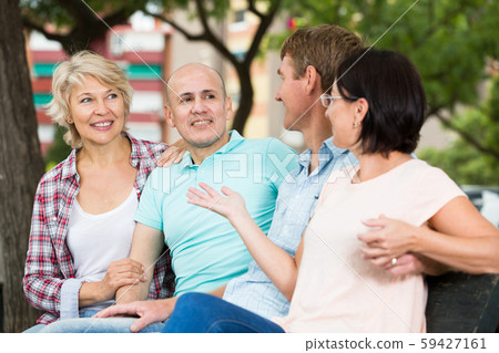 mature cheerful males and females talking outdoors mature cheerful males and females talking outdoors 59427161