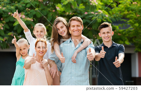 Portrait of large family of six standing and holding thumbs up Portrait of large family of six standing and holding thumbs up 59427203