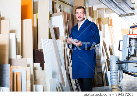 portrait of man in uniform choosing tight wooden bar in picture framing atelier portrait of man in uniform choosing tight wooden bar in picture framing atelier 59427205