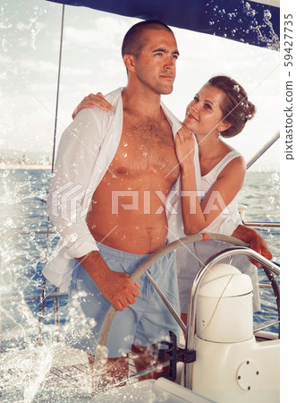 Couple steering yacht along Spanish coast 59427735