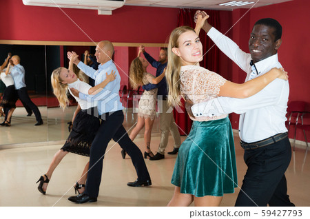 Positive adult couples dancing tango together in modern studio 59427793