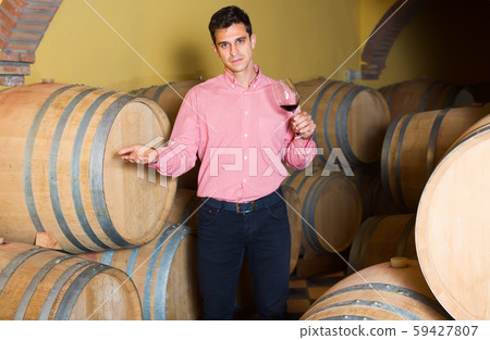positive man posing in winery cellar 59427807