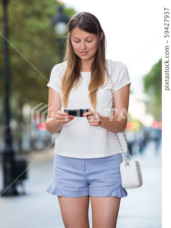 Romantic woman walking with phone Romantic woman walking with phone 59427937
