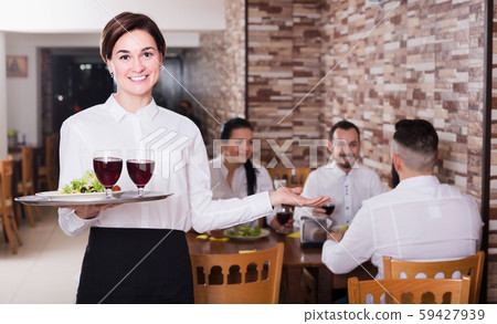 Smiling woman waitress carrying order for visitors Smiling woman waitress carrying order for visitors 59427939