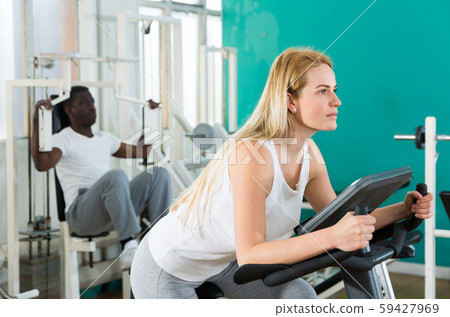 Man and women exercising on simulators Man and women exercising on simulators 59427969