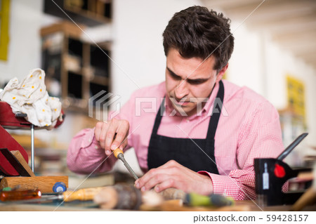 Craftsman in uniform working in carpentry 59428157
