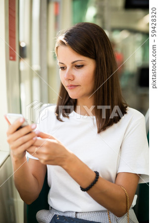 Woman using smartphone in public transport Woman using smartphone in public transport 59428320
