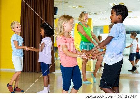 Positive little boys and girls dancing pair dance in the ballet studio Positive little boys and girls dancing pair dance in the ballet studio 59428347