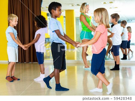 Positive little boys and girls dancing pair dance in the ballet studio Positive little boys and girls dancing pair dance in the ballet studio 59428348