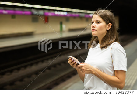 Woman holding smartphone in underground Woman holding smartphone in underground 59428377