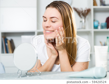 Young woman is satisfied of quality her skin in with mirror 59428524