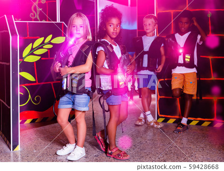 Little african and european girls standing back to back with las 59428668