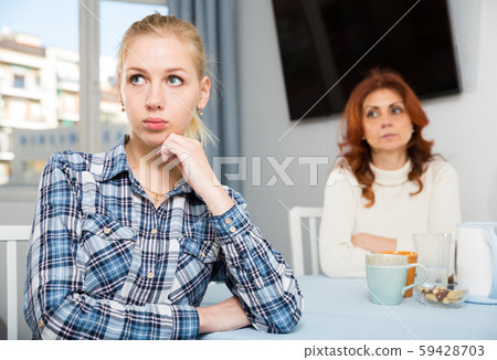 Portrait of sad mature woman trying to talk with daughter in home Portrait of sad mature woman trying to talk with daughter in home 59428703
