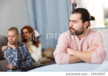 Angry wife and mother-in-law rebuking young man Angry wife and mother-in-law rebuking young man 59429097