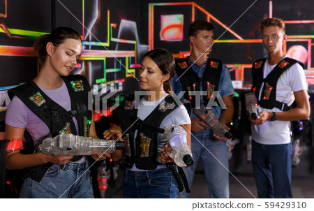 Two young girls talking during laser tag game Two young girls talking during laser tag game 59429310
